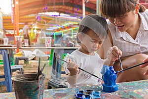 Asian cute girl baby and mother is painting colorful.