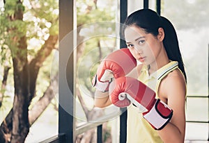 Asian cute girl boxer wearing gloves boxer, sparring with determination and seriousness.