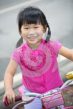 Asian cute girl enjoy to ride bicycle at the park ,