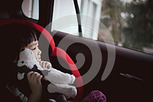 Asian cute girl play puppy doll in car seat.