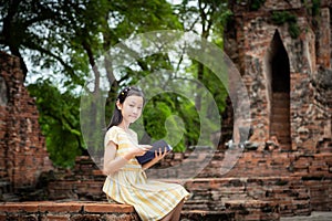 Asian cute girl relaxing outdoors while read history book,Student enjoy learning