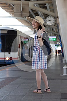 Asian cute girl waving goodbye before go to travel at skytrain photo