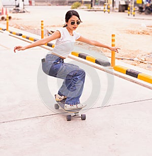 Asian cute girl or woman surf skateboard and abbreviate her body on street of skateboard way in daylight time, summer holiday photo