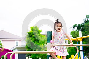 Asian cute little girl having fun on playground outdoors in summer time. Sport activities for kids concept