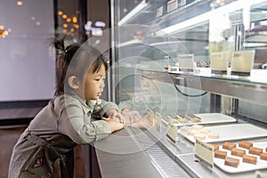 Asian cute little girl looking excited in bakery counter