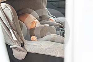 Asian cute newborn baby sleeping in modern car seat.