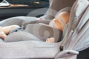 Asian cute newborn baby sleeping in modern car seat.