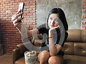 Asian cute teenage woman selfie with smart phone.