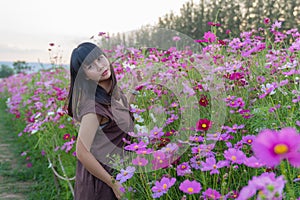 Asian cute young woman joyful, smiling with pink cosmos background