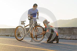 Asian cyclist couple assembles bikes for a morning bike ride by the lake