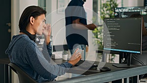 Asian database programer writing code on computer