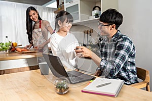 Asian daughter girl serve water to dad working from home