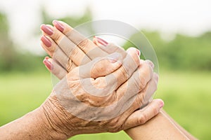 Asian daughter greeting or pay respect to her mother, two hands holding each others