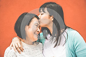 Asian daughter kissing mum on mother day - Happy family people enjoying time togehter - Love, motherhood lifestyle, tender moments