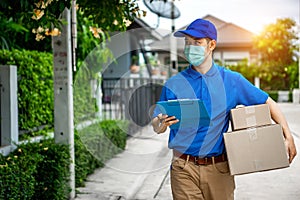 Asian delivery man in blue t-shirt carrying parcel box photo