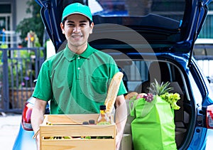 Asian delivery man delivering food, fruit, juice and vegetable to customer home - online grocery shopping service concept