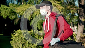 Asian delivery man in red uniform with face mask carrying bag of food delivering food to customer home during covid