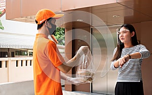 Asian delivery man sending late food in plastic bag to customer who waiting order and point finger to time in watch wrist while