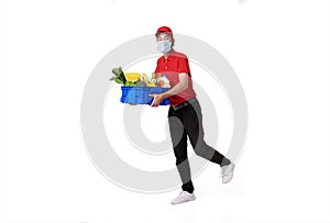 Asian delivery man wearing face mask in red uniform holding fresh food basket isolated over white background. express delivery