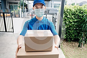 Asian Delivery man wearing mask send a package carton on front receiver shipping deliver social distancing