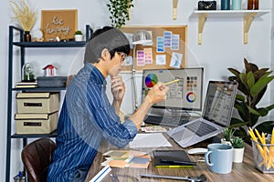 Asian Designer or creative Occupation Design Studio artist working on graphic computer at the office using graphics tablet and a