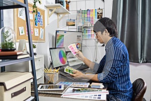 Asian Designer or creative Occupation Design Studio artist working on graphic computer at the office using graphics tablet and a