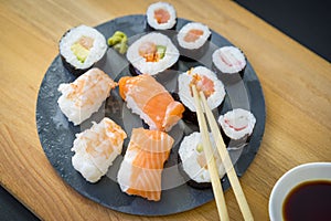 Asian dinner, Sushi on a wooden table on black slate plate with