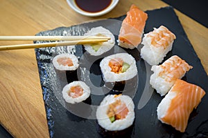 Asian dinner, Sushi on a wooden table on black slate plate with