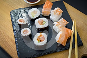 Asian dinner, Sushi on a wooden table on black slate plate with