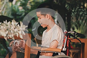 Asian disability child on wheelchair looking, talking with the girl doll in hands