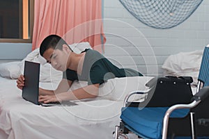 Asian disable child on the bed using notebook