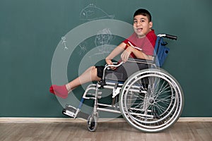 Asian disabled boy on wheelchair showing his painting on wall with happy and proud. Idea for learning ability of handicapped kid
