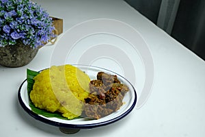 Asian dish pulut kuning with chicken curry and sambal