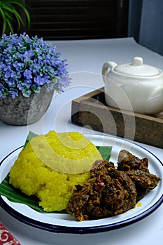 Asian dish pulut kuning with chicken curry and sambal