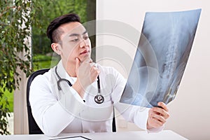 Asian doctor analysing X-ray