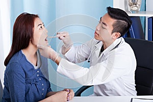 Asian doctor examining his female patient