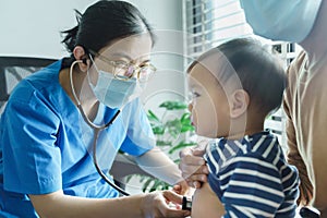 Asian doctor examining and listening lungs of little baby boy with stethoscope