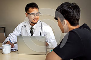 Asian doctor giving medical consultation diagnostic to young man in hospital office