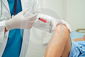 Asian doctor inject Hyaluronic acid platelet rich plasma into the knee of senior woman to walk without pain