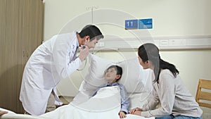 Asian doctor making rounds in child patient`s hospital ward