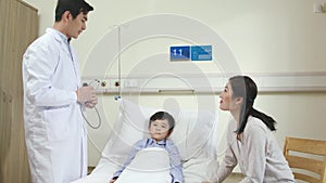Asian doctor making rounds in child patient`s hospital ward