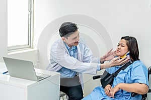 Asian doctor man checking condition of fat woman patient is injuries the arm and neck