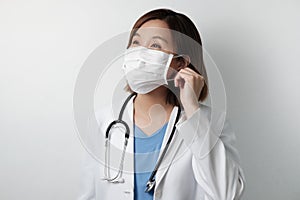 Asian doctor smile under the medical mask to protect and fight infection from germ, bacteria,, corona , sars , influenza