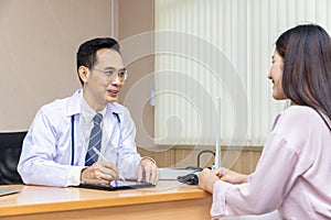 Asian doctor talking and explaining test result and diagnosis to demoralized patient in hospital