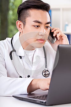 Asian doctor talking on phone
