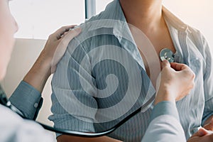 Asian doctor is using a stethoscope listen to the heartbeat of the elderly patient