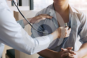 Asian doctor is using a stethoscope listen to the heartbeat of the elderly patient