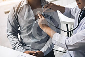 Asian doctor is using a stethoscope listen to the heartbeat of the elderly patient