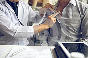 Asian doctor is using a stethoscope listen to the heartbeat of the elderly patient