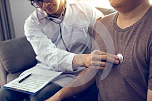 Asian doctor is using a stethoscope listen to the heartbeat of the elderly patient